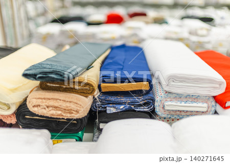 Assorted colorful fabric rolls and textile materials displayed in retail store 140271645