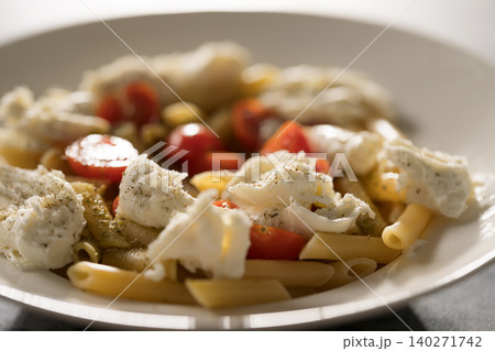 Penne pasta with mozzarella, pesto and fresh cherry tomatoes Penne pasta with mozzarella, pesto and fresh cherry tomatoes 140271742