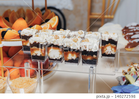 Delicious layered desserts sit on clear stands Delicious layered desserts sit on clear stands 140272598