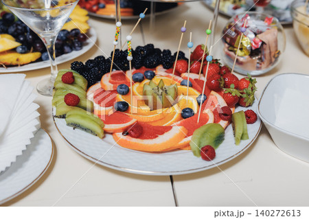 Colorful fruit platter arranged artistically on a white plate Colorful fruit platter arranged artistically on a white plate 140272613