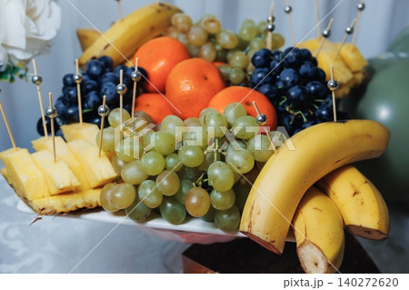 Fresh fruit platter with bananas, grapes, oranges, and pineapple slices 140272620