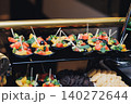 Brightly colored fruit cups sit neatly on a black tray 140272644