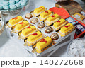 Delicate yellow pastries gleam with red sprinkles 140272668