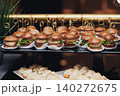 Golden-topped buns hold savory fillings, served on tiered trays 140272675