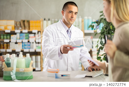 Man pharmacist is working at computer, communicate with girl customer Man pharmacist is working at computer, communicate with girl customer 140272774