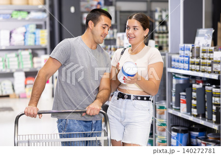 Interested talking and selecting paints in building supplies store Interested talking and selecting paints in building supplies store 140272781