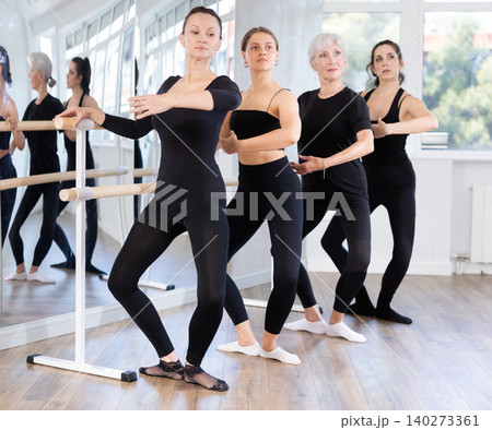 Women in ballet class perform composition with demi plie with participation of mature female mentor Women in ballet class perform composition with demi plie with participation of mature female mentor 140273361