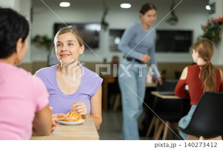 Girl in cafe sits near girl companion, has nice conversation and discusses news of day 140273412