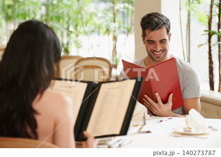 Happy couple, date and reading menu at restaurant for fine dining, romance or ordering food together. Young man and woman looking at brochure with smile for meal, dinner or decision in eating choice Happy couple, date and reading menu at restaurant for fine dining, romance or ordering food together. Young man and woman looking at brochure with smile for meal, dinner or decision in eating choice 140273787