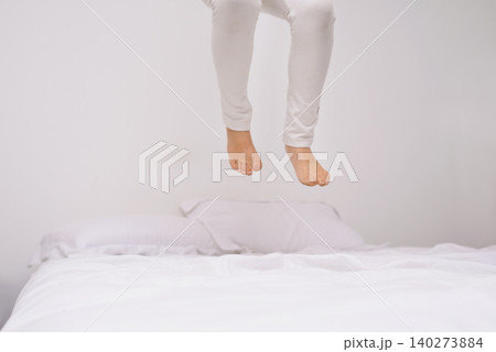 Jumping, bed and kid with fun, energy and morning in a bedroom with game and feet. Youth, hop and home with a excited child on a duvet in air with crazy play, leap and legs in house with white wall Jumping, bed and kid with fun, energy and morning in a bedroom with game and feet. Youth, hop and home with a excited child on a duvet in air with crazy play, leap and legs in house with white wall 140273884