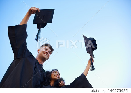 Graduation, university and students with blue sky for learning, studying and knowledge on academy campus. Education, friends and man and woman with hat for celebration, graduate ceremony and college Graduation, university and students with blue sky for learning, studying and knowledge on academy campus. Education, friends and man and woman with hat for celebration, graduate ceremony and college 140273985