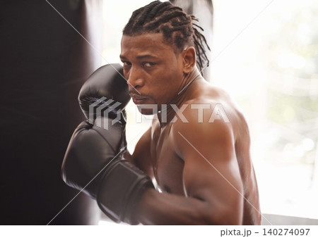Challenge, portrait and black man with boxing gloves in gym for fitness, fight and competition training. Power, muscle and serious face of champion boxer at workout with confidence in sports club. Challenge, portrait and black man with boxing gloves in gym for fitness, fight and competition training. Power, muscle and serious face of champion boxer at workout with confidence in sports club. 140274097