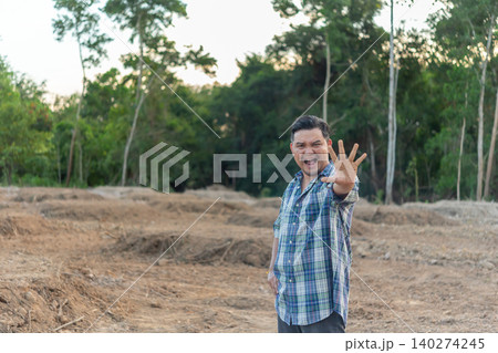 Adult man making stop gesture raised hand an outdoor rural area expressing warning refusal attention or personal boundaries against natural backdrop Adult man making stop gesture raised hand an outdoor rural area expressing warning refusal attention or personal boundaries against natural backdrop 140274245
