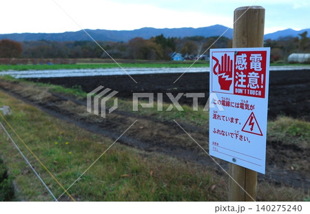 農地の電気柵に添えて立てられた「感電注意」の警告表示 農地の電気柵に添えて立てられた「感電注意」の警告表示 140275240