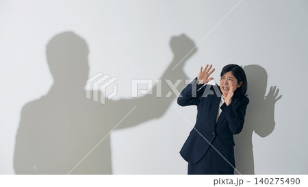 男性のシルエットに叩かれる女性ビジネスパーソン 男性のシルエットに叩かれる女性ビジネスパーソン 140275490