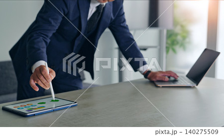 ノートパソコンとタブレットPCを使って作業する男性 ノートパソコンとタブレットPCを使って作業する男性 140275509