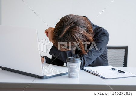 デスクで疲れてうなだれる女性会社員 デスクで疲れてうなだれる女性会社員 140275815