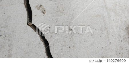 White concrete wall surface with a prominent vertical crack in the middle 140276600
