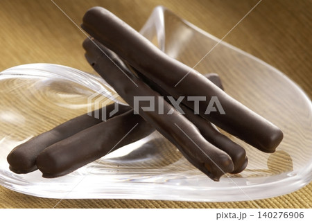 ガラス皿に乗ったチョコレートがけオレンジピールスティック 140276906