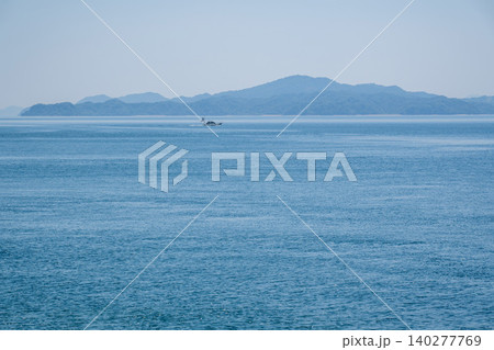 遠くに小さな船と島だけの波静かな瀬戸内海の風景 遠くに小さな船と島だけの波静かな瀬戸内海の風景 140277769