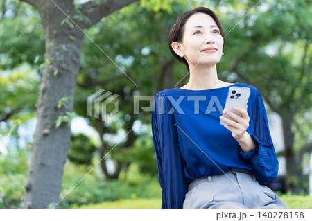 屋外でスマートフォンを操作している若い女性 140278158
