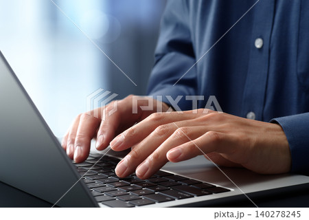オフィスのデスクでノートパソコンを使うビジネスパーソン。手とキーボードのクローズアップ。ビジネスでの 140278245