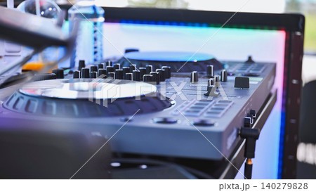 Dj set with mixer and colorful led panel lighting up the background 140279828