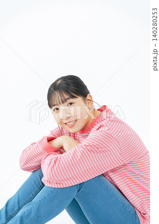 床に座るカジュアルウェアを着た10代女性の全身写真 140280253