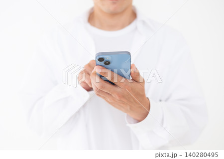 スマホを持つ白いシャツを着たミドル男性白バック スマホを持つ白いシャツを着たミドル男性白バック 140280495