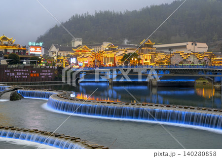 ZHANGJAJIE, China. Evening view of the bridge over the Suoxi River and the lights of the city in fog ZHANGJAJIE, China. Evening view of the bridge over the Suoxi River and the lights of the city in fog 140280858