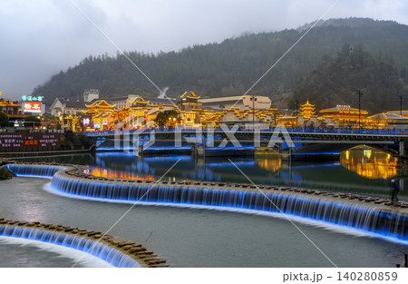 ZHANGJAJIE, China. Evening view of the bridge over the Suoxi River and the lights of the city in fog ZHANGJAJIE, China. Evening view of the bridge over the Suoxi River and the lights of the city in fog 140280859