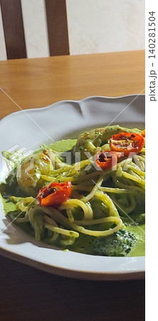 Basil spaghetti made with al dente pasta tossed in fragrant basil sauce, blended with olive oil and garlic, creating a simple yet flavorful dish with fresh green color and aromatic taste Basil spaghetti made with al dente pasta tossed in fragrant basil sauce, blended with olive oil and garlic, creating a simple yet flavorful dish with fresh green color and aromatic taste 140281504