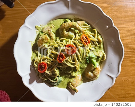 Basil spaghetti made with al dente pasta tossed in fragrant basil sauce, blended with olive oil and garlic, creating a simple yet flavorful dish with fresh green color and aromatic taste 140281505
