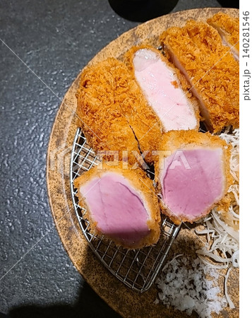 Crispy tonkatsu, a Japanese-style breaded and deep-fried pork cutlet, served with shredded cabbage and drizzled with savory sauce. A delightful balance of crunchy texture and juicy meat. Crispy tonkatsu, a Japanese-style breaded and deep-fried pork cutlet, served with shredded cabbage and drizzled with savory sauce. A delightful balance of crunchy texture and juicy meat. 140281546