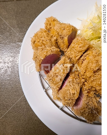 Crispy tonkatsu, a Japanese-style breaded and deep-fried pork cutlet, served with shredded cabbage and drizzled with savory sauce. A delightful balance of crunchy texture and juicy meat. Crispy tonkatsu, a Japanese-style breaded and deep-fried pork cutlet, served with shredded cabbage and drizzled with savory sauce. A delightful balance of crunchy texture and juicy meat. 140281550