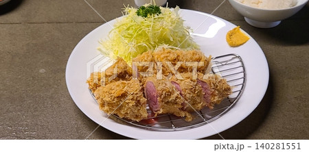 Crispy tonkatsu, a Japanese-style breaded and deep-fried pork cutlet, served with shredded cabbage and drizzled with savory sauce. A delightful balance of crunchy texture and juicy meat. Crispy tonkatsu, a Japanese-style breaded and deep-fried pork cutlet, served with shredded cabbage and drizzled with savory sauce. A delightful balance of crunchy texture and juicy meat. 140281551