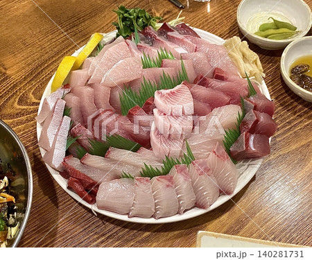 Fresh and delicate sashimi slices, beautifully presented with vibrant colors and perfect cuts. This traditional Japanese delicacy highlights the pure flavors of premium seafood. 140281731