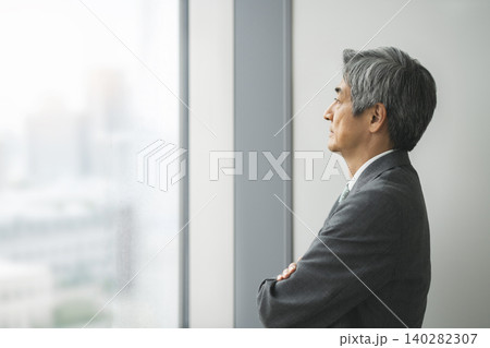 腕組みをして窓の外を見る60代のビジネスマン　横顔 140282307