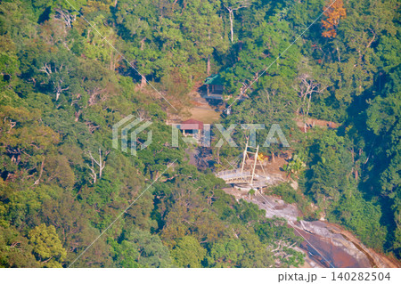 Rocky mountain waterfall surrounded by dense tropical rainforest near Langkawi Sky Bridge Malaysia 140282504