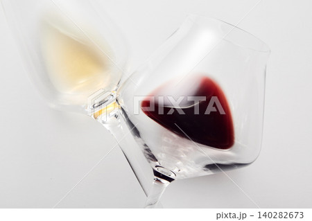 Wineglasses with red, white wine lying with stems crossed. 140282673