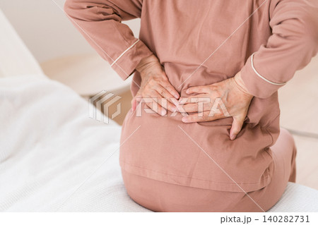 ベッドの上で腰を痛がるシニア女性 ベッドの上で腰を痛がるシニア女性 140282731