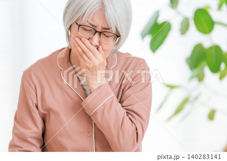 体調不良で吐き気がするパジャマ姿のシニア女性 体調不良で吐き気がするパジャマ姿のシニア女性 140283141