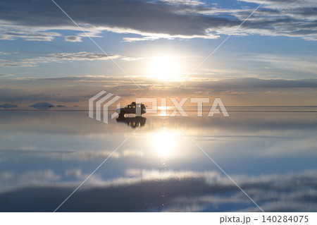 Serene car reflection on uyuni salt flat with water during sunset in bolivia Serene car reflection on uyuni salt flat with water during sunset in bolivia 140284075