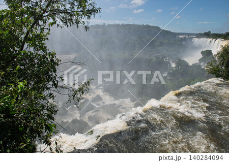 Majestic iguazu falls pouring water over cliff creating mist in breathtaking wild nature Majestic iguazu falls pouring water over cliff creating mist in breathtaking wild nature 140284094
