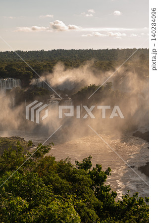 Majestic mist above powerful iguazu falls creates awe in lush green jungle Majestic mist above powerful iguazu falls creates awe in lush green jungle 140284096