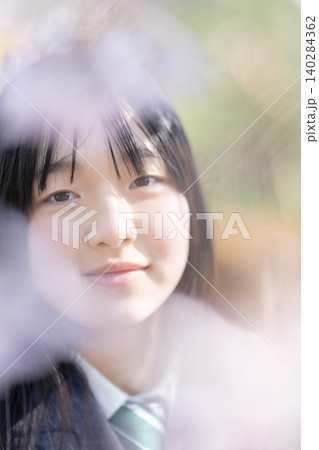 満開の桜と女子生徒の笑顔 前ボケ 青春のイメージ 満開の桜と女子生徒の笑顔 前ボケ 青春のイメージ 140284362