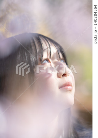 満開の桜と女子生徒の笑顔 前ボケ 青春のイメージ 満開の桜と女子生徒の笑顔 前ボケ 青春のイメージ 140284364