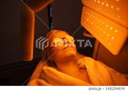 Woman undergoing skin therapy with light treatment in a spa setting 140284634