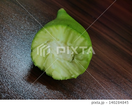 sliced green lime on wooden board, Cross section of green gourd, Sliced fresh vegetable, Healthy green produce sliced green lime on wooden board, Cross section of green gourd, Sliced fresh vegetable, Healthy green produce 140284845