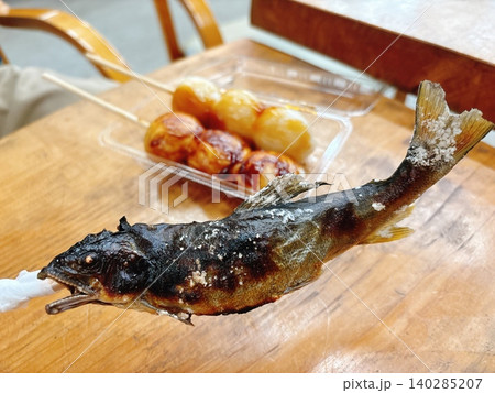 炭火で焼かれた美味しそうな鮎の塩焼きとお団子の屋台飯 炭火で焼かれた美味しそうな鮎の塩焼きとお団子の屋台飯 140285207